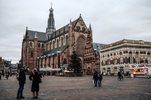 Bezoekers op de kerstmarkt Haarlem tussen verlichte kramen op en rond de Grote Markt
